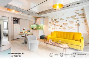 a living room with a yellow couch and a kitchen at Beauquartier - Sentier in Paris