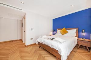 1 dormitorio con 1 cama grande y pared azul en Farringdon Serviced Apartments en Londres