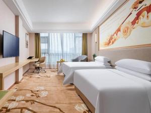Habitación de hotel con 2 camas y TV de pantalla plana. en Vienna Hotel Zhejiang Quzhou Jianglang Mountain Scenic Area Xiakou, en Nantang