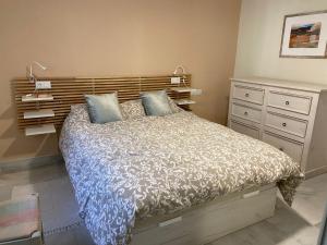 een slaapkamer met een groot bed en een dressoir bij Apartamento entero en La Carihuela a 50 m de la playa in Torremolinos