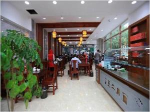 a restaurant with people sitting at tables in a restaurant at Vienna Hotel Qinghai Xining Deling Halu City East Wanda Plaza in Xining