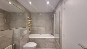 uma casa de banho com uma banheira, um WC e um chuveiro em Chambre d'hôte - hypercentre em Annemasse