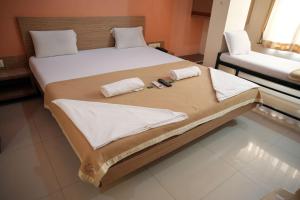 ein großes Bett mit zwei Kissen und Handtüchern darauf in der Unterkunft HOTEL SAI SURYA in Shirdi