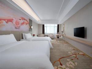 Habitación de hotel con 2 camas y TV de pantalla plana. en Vienna Hotel Anhui Taihe Baitai Xingma International, en Yuzhuang