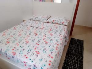 uma cama com um edredão floral e almofadas em Chácara a 6km do centro! em Poços de Caldas