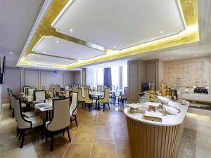 um restaurante com mesas e cadeiras num quarto em Vienna Hotel Jiangxi Shangrao High-Speed Railway Station em Shangrao