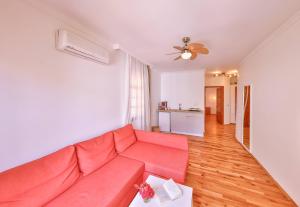 a living room with a red couch and a kitchen at Yoga House Kaş in Kaş