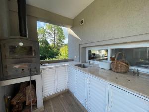 uma cozinha com armários brancos e um fogão em Casa Quinta Moderna - Country Golf em Gualeguaychú