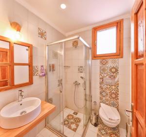 a bathroom with a shower and a sink and a toilet at Yoga House Kaş in Kaş