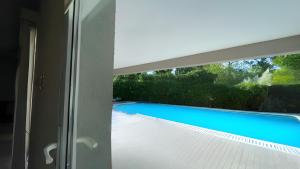uma vista para uma piscina através de uma janela em Casa Quinta Moderna - Country Golf em Gualeguaychú