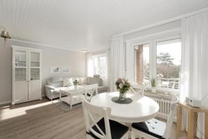 - un salon avec une table et des chaises blanches dans l'établissement Strandfee Wohnung 21, à Grömitz