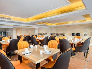 ein Restaurant mit Tischen und Stühlen in einem Zimmer in der Unterkunft Vienna Hotel Guangxi Tiandong Times Plaza in T'ien-tung