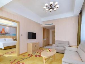 - un salon avec un canapé et un lit dans l'établissement Vienna Hotel Shandong Zaozhuang Qingtan Road, à Zhaozhuang