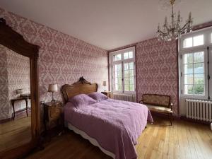 1 dormitorio con cama morada y papel pintado de color rosa en Castel Saint Laurent en Langeais