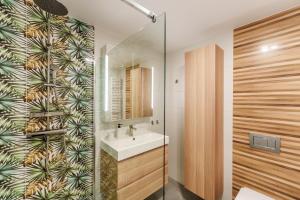 a bathroom with a sink and a glass shower at Apartament na Sosnowej Wydmie - Osiedle Shellter in Rogowo