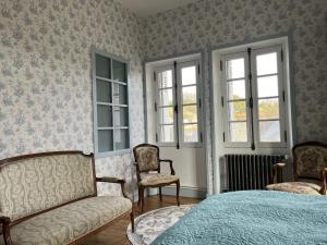 朗熱的住宿－Castel Saint Laurent，一间卧室配有一张床、两把椅子和窗户