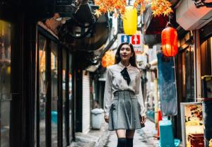 Una donna cammina per una strada di città di Lien Nishi Shinjuku a Tokyo