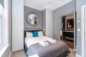 a bedroom with a bed with a mirror and a tub at Luxury 1BR, 2 min Putney Train St, 5 min to Tube in London