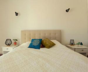 a bedroom with a bed with two pillows on it at Garden Luz House in Lagos