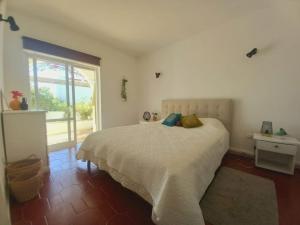 a bedroom with a bed and a large window at Garden Luz House in Lagos