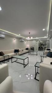 una sala de estar con sofás y mesas en un suelo de baldosa. en شاليهات ديتيلز الفندقية, en Al Khafji