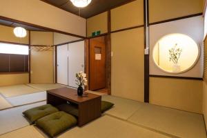 a room with a table and a vase of flowers at Bijou Suites Goen in Osaka