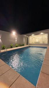 una piscina por la noche en un hotel en شاليهات ديتيلز الفندقية, en Al Khafji