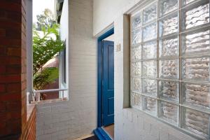 a blue door leading to a room with a window at Broadwater Resort Como in Perth