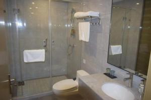 een badkamer met een douche, een toilet en een wastafel bij Borrman Hotel Shnaghai Baoshan Yangtai Road in Baoshan
