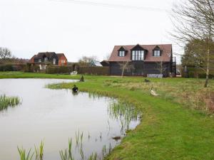 a pond in front of a house with ducks in it at 1 Bed in Horsham 86961 in Rudgwick