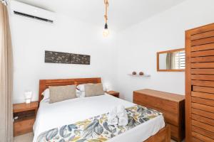 un dormitorio con una cama con sábanas blancas en Athena Villa D10 by Host Agents, en Grand Baie