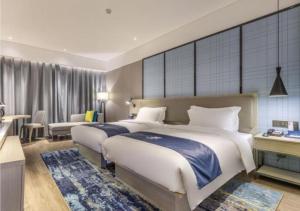 1 dormitorio con 2 camas y sala de estar en Echarm Hotel Quanzhou Liming Vocational University Ling Show World en Donghai