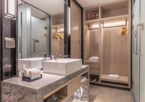 baño con lavabo y espejo grande en Echarm Hotel Quanzhou Liming Vocational University Ling Show World en Donghai