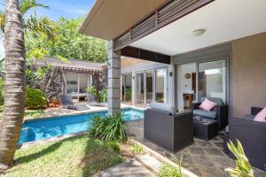 a backyard with a swimming pool and a house at Athena Villa D10 in Grand-Baie