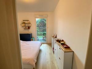 a bedroom with a bed and a desk and a window at Le jardin de Clémentine & Julien in Saint-Ouen