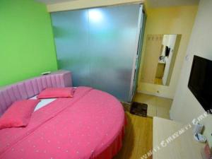 a pink bed in a room with a green wall at JTOUR Inn Wuhan Optics Valley Plaza Pedestrian Street Metro Station in Liufangling
