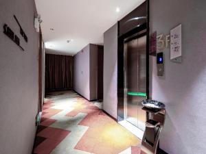 an empty hallway of a building with a glass door at Borrman Hotel Wuzhou College Fumin Road in Wuzhou