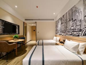 Cette chambre comprend 2 lits et une télévision. dans l'établissement City Comfort Inn Jingzhou Fantawild Shashi Middle School, à Juzhang He
