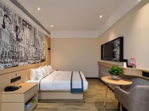 Cette chambre comprend un lit et une télévision. dans l'établissement City Comfort Inn Jingzhou Fantawild Shashi Middle School, à Juzhang He