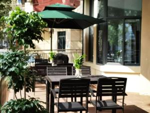 una mesa con sillas y una sombrilla en el patio en GreenTree Eastern Hotel Chongqing Xiejiawan Light Rail Station en Jiulongpo