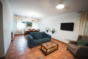 uma sala de estar com duas cadeiras azuis e uma mesa em Casa Rural Dehesa de Solana em Herrera de Alcántara