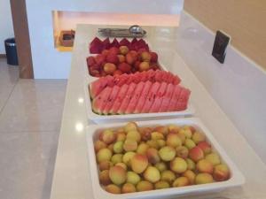 zwei Tabletts Obst und Gemüse auf einer Theke in der Unterkunft GreenTree Eastern Hotel Kashgar Oid City Xiangfei Park in Kashgar