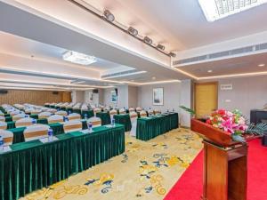 een conferentiezaal met tafels en stoelen en een podium bij Gya Hotel Zhuhai International Airport New Town in Baigaonongchang