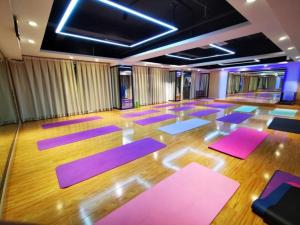 Pokój z fioletowymi matami i drewnianą podłogą w obiekcie Green Tree Inn Zhuhai International Airport Huafa Shangdu w mieście Baigaonongchang