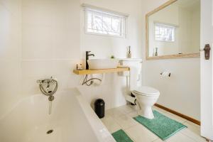 a bathroom with a white tub and a toilet at Swakopmund Seafront Cottage in Swakopmund