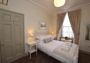 1 dormitorio con cama blanca y ventana en Fenkle, en Alnwick
