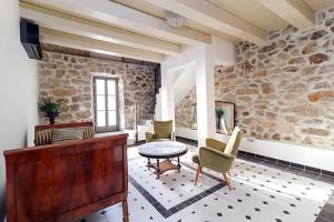 een woonkamer met een stenen muur en een tafel en stoelen bij Deluxe Nature Resort Galovi Dvori in Rab