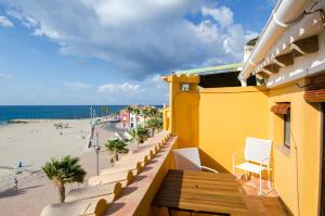 een balkon met een geel gebouw en een strand bij Mediterranean Terraces - Beach Paradise in Villajoyosa