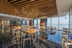 a restaurant with tables and chairs and a view of the water at Grand Madison Jiujiang Yuexi Lake in Jiujiang