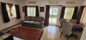 a living room with a couch and a chair at Kamuli Cottage in Entebbe